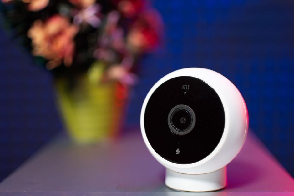 Close-up shot of a modern circular security camera with blurred background.